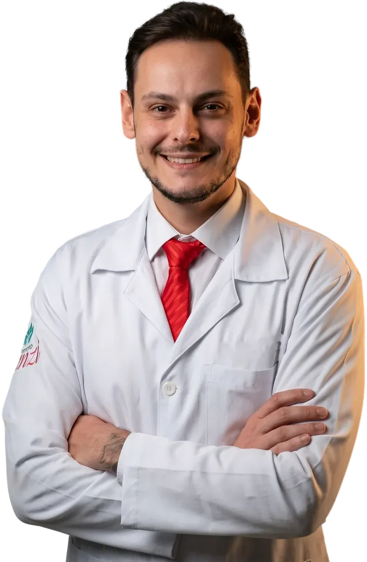 Dr. Rafael Canzi de jaleco branco, sorrindo, com os braços cruzados